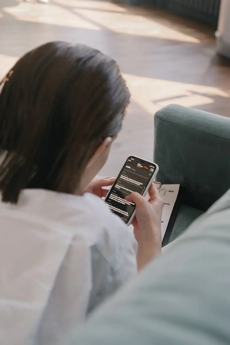 A woman uses her smartphone inside, viewed from behind. Perfect for lifestyle or technology themes.