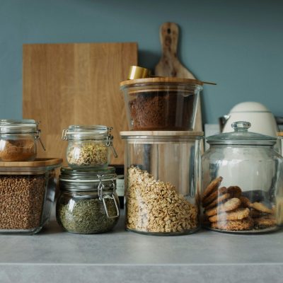 Neatly arranged glass jars with cookies, oats, spices, and ingredients on a kitchen counter.